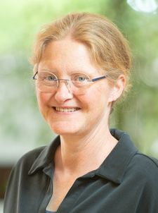 Lächelnde Frau mit Brille und zurückgebundenem Haar