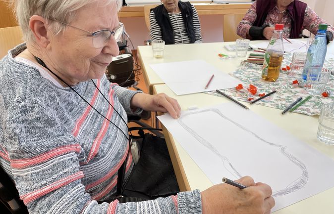 Ältere Frauen zeichnen bei Forscherwerkstatt am Tisch
